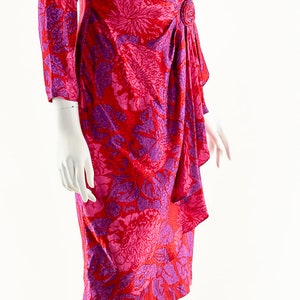 May include: A red and purple floral print wrap dress with a button detail at the waist.