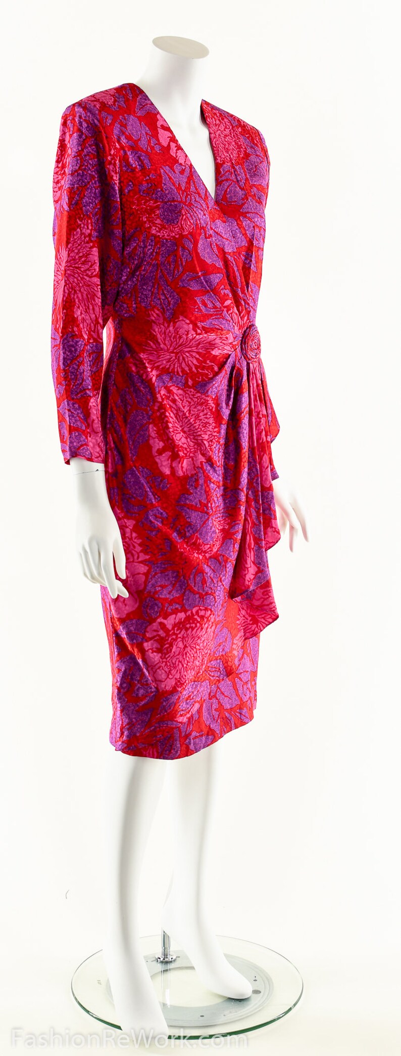 May include: A red and purple floral print wrap dress with a button detail at the waist.