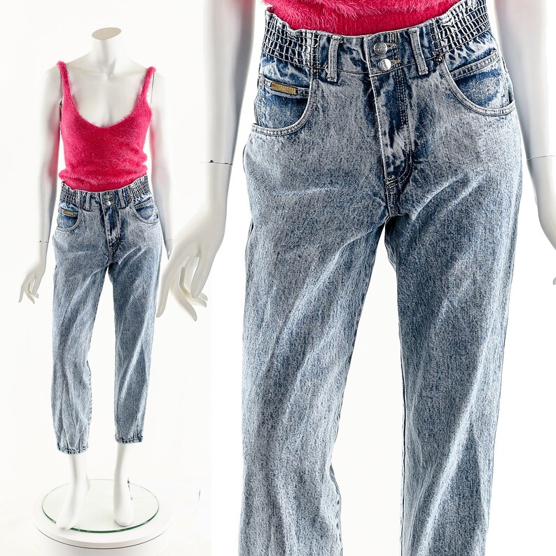 May include: Light blue acid wash denim jeans with a high waist and a relaxed fit. The jeans have a faded look and a slightly cuffed hem.