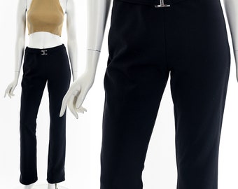 May include: Black pants with a wide waistband and a silver buckle. The pants have a straight leg and a slightly cropped length.