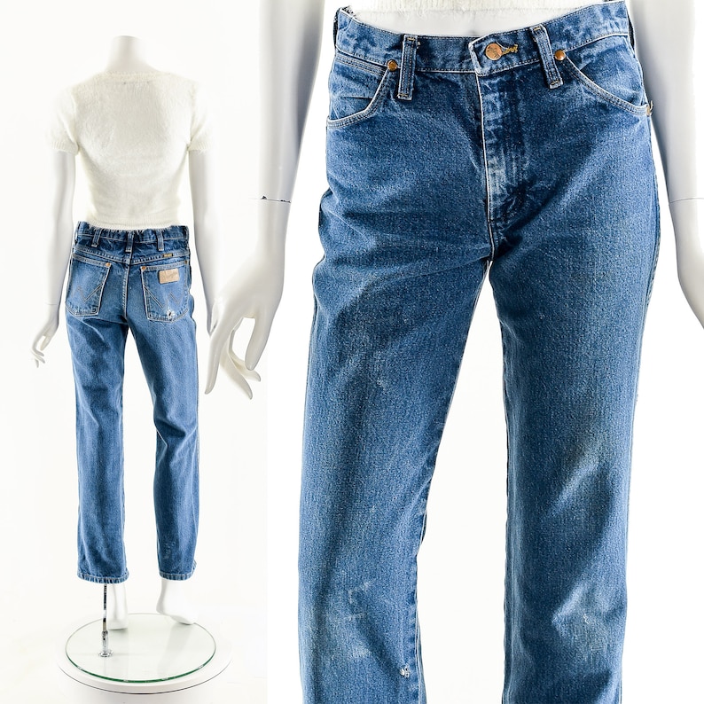 Puede incluir: Un par de pantalones vaqueros azules de mezclilla con corte recto. Los vaqueros tienen un lavado claro y est&aacute;n desgastados con decoloraci&oacute;n y marcas de desgaste. Los vaqueros tienen un estilo cl&aacute;sico de cinco bolsillos con cierre de bot&oacute;n.