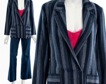 May include: A navy blue and gray striped blazer with two front pockets and a double-breasted button closure. The blazer is paired with blue jeans. The outfit is displayed on a mannequin.