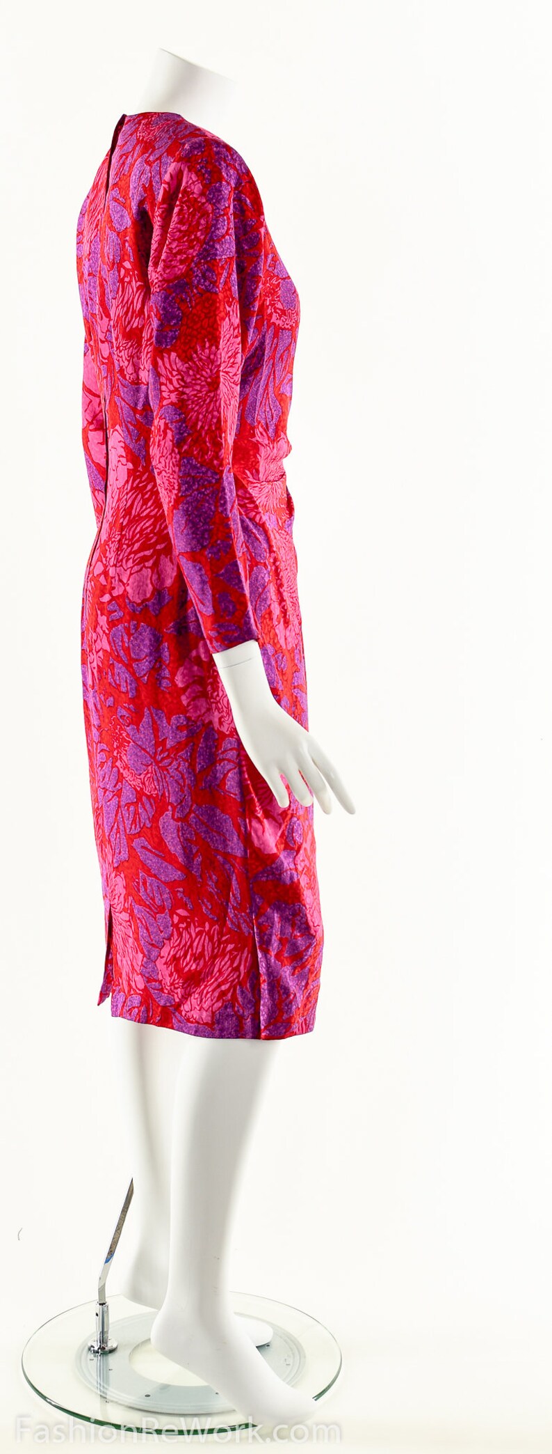 May include: A pink and purple floral print dress with long sleeves. The dress is fitted and has a slight A-line shape.