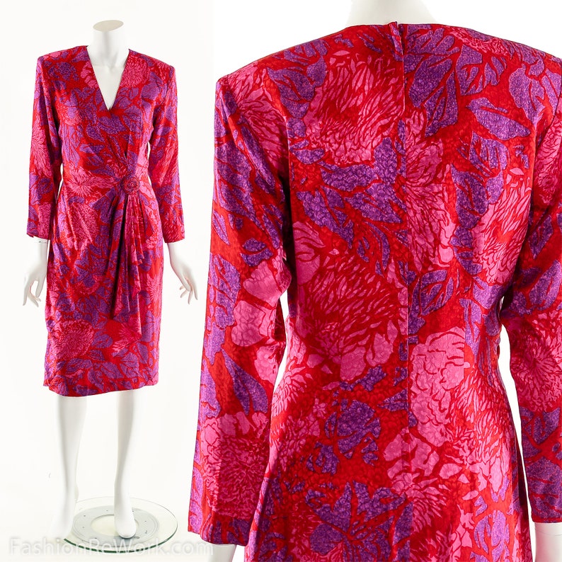 May include: A long-sleeved dress with a V-neckline and a wrap-style bodice. The dress is made of a red and purple floral print fabric.