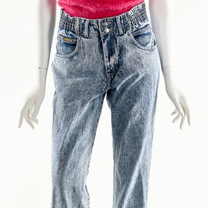 May include: A pink fuzzy tank top with a pair of light blue denim jeans with a high waist.