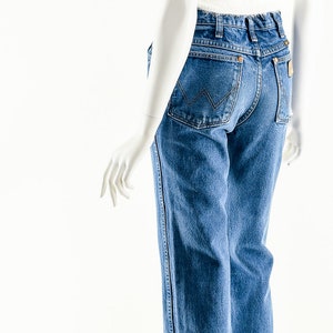 Puede incluir: Un par de pantalones vaqueros azules de mezclilla con corte recto. Los vaqueros tienen un dise&ntilde;o cl&aacute;sico de cinco bolsillos y un lavado claro.