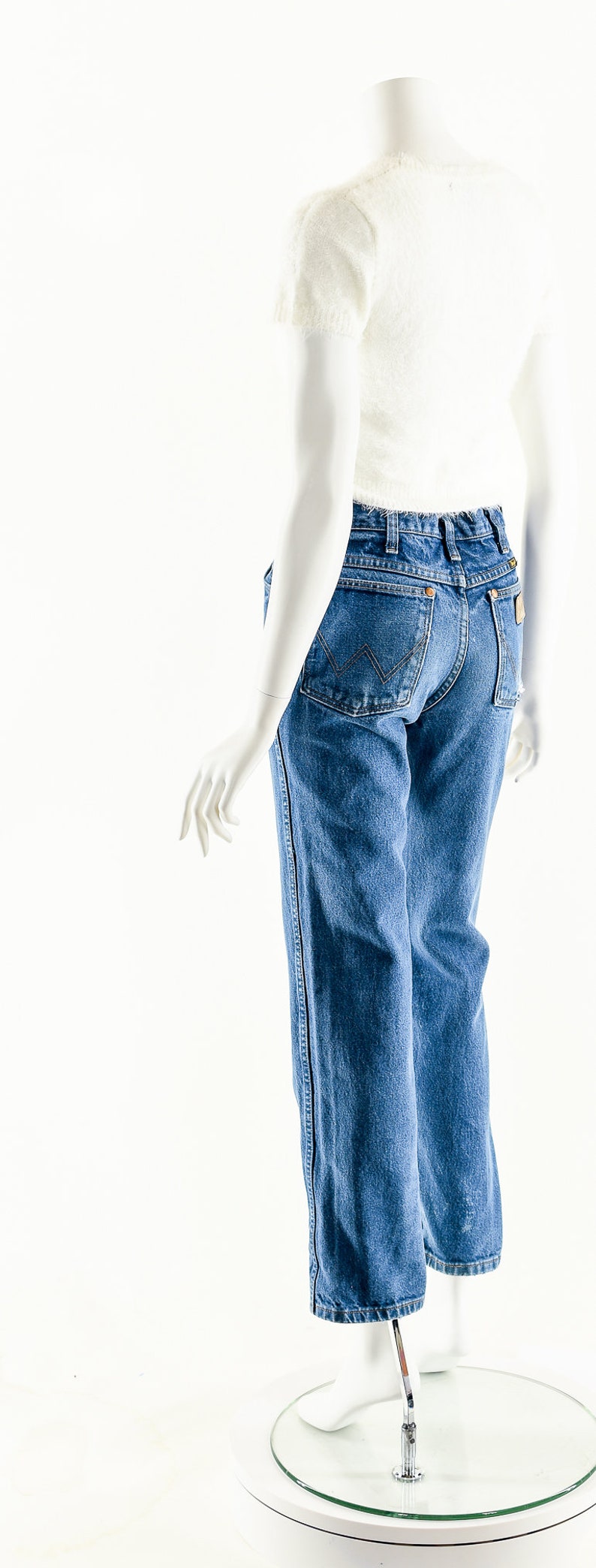 Puede incluir: Un par de pantalones vaqueros azules de mezclilla con corte recto. Los vaqueros tienen un dise&ntilde;o cl&aacute;sico de cinco bolsillos y un lavado claro.