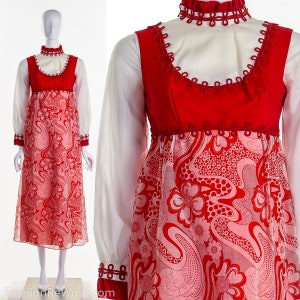 Pode incluir: Um vestido vermelho e branco de manga comprida com gola alta e padrão floral. O vestido tem uma gola branca e uma guarnição vermelha ao redor do pescoço e das mangas.