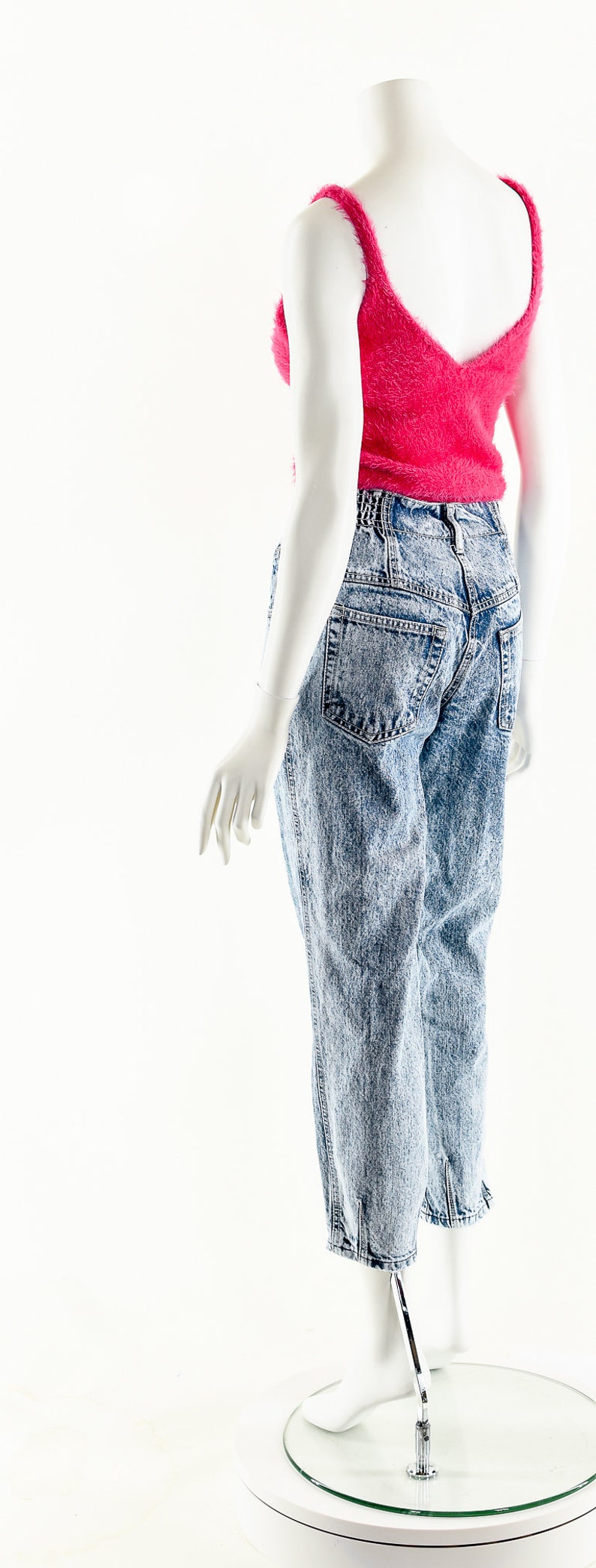 May include: A mannequin wearing a pink fuzzy crop top and light blue acid wash denim jeans.