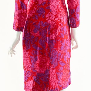 May include: A red and purple floral print dress with long sleeves. The dress has a fitted silhouette and a slightly flared skirt.