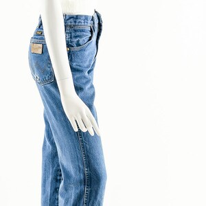 Puede incluir: Un su&eacute;ter blanco peludo recortado y jeans de mezclilla azul en un maniqu&iacute; blanco.