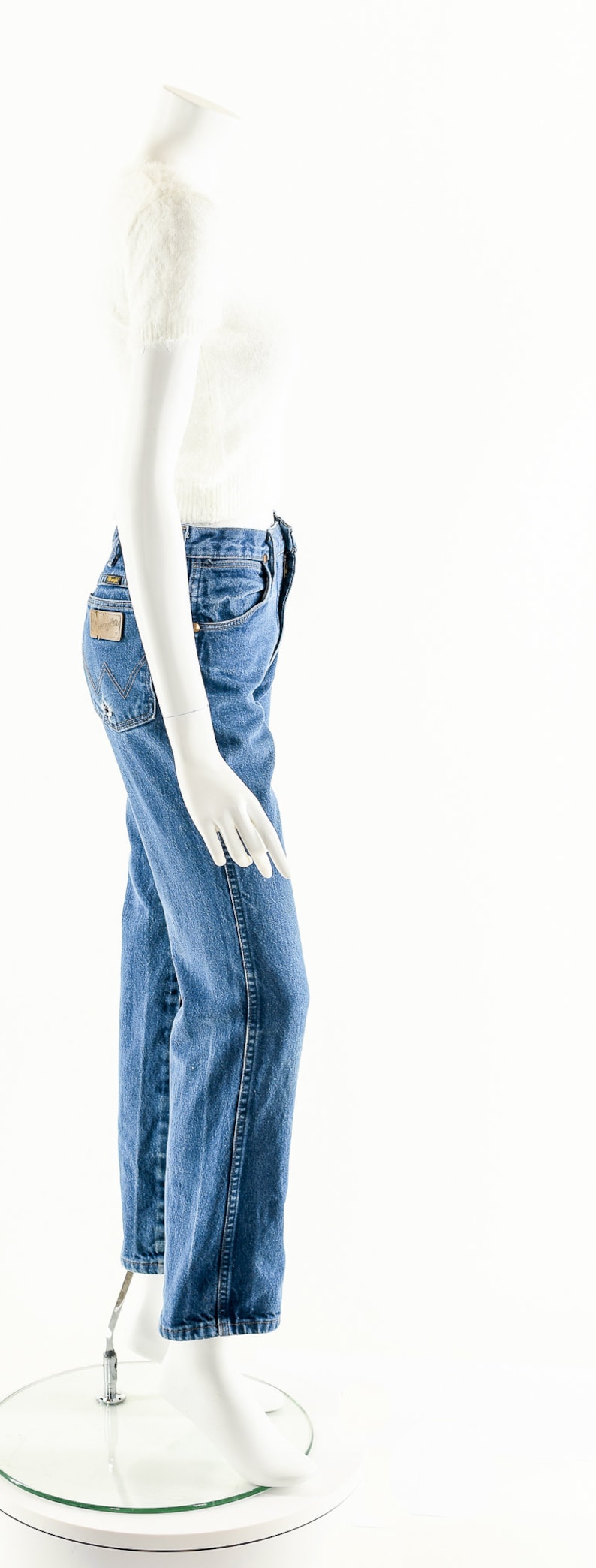 Puede incluir: Un su&eacute;ter blanco peludo recortado y jeans de mezclilla azul en un maniqu&iacute; blanco.