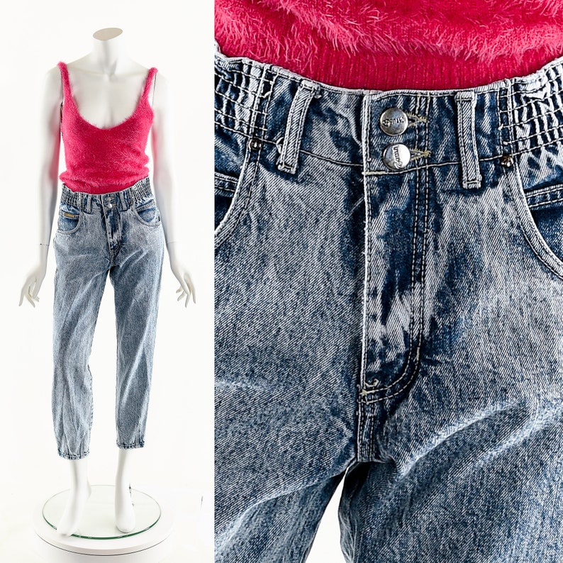 May include: Light blue acid wash denim jeans with a high waist and a relaxed fit. The jeans have a button fly and a double button closure. The jeans are made of a soft, comfortable denim.