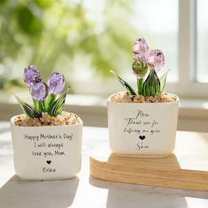 May include: Two white square ceramic pots with glass tulip flowers. One has purple tulips, the other pink. Text on the pots reads "Happy Mother's Day!" and "Mom, Thank you for helping me grow."