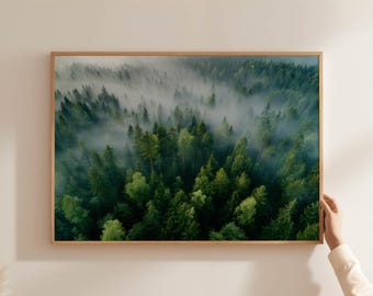May include: A framed landscape print featuring a dense forest shrouded in mist. The image showcases a vibrant array of green trees, with varying shades and textures. The wooden frame adds a natural touch to the artwork, enhancing the overall aesthetic.