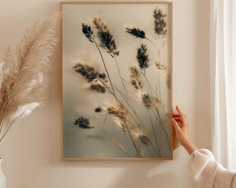 May include: A framed print featuring a close-up of tall, feathery grasses in shades of brown and black against a soft, muted background. The artwork is encased in a light brown wooden frame, creating a natural and serene aesthetic.