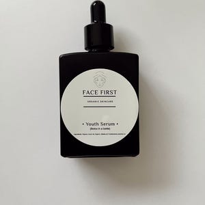 May include: A black square bottle of Face First Youth Serum with a dropper top. The white label features the brand name and the words "Youth Serum (Botox in a bottle)". The bottle is on a white background.