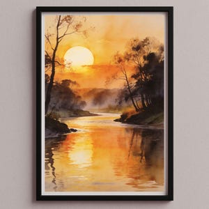 May include: A framed watercolor painting depicts a sunset over a river. The sky is a blend of orange and yellow, with the sun partially obscured. The river reflects the warm colors, and trees line the banks.