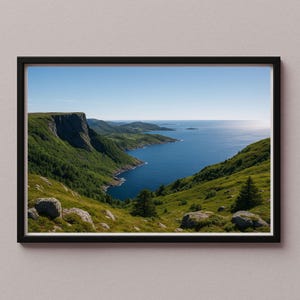 Könnte beinhalten: Ein gerahmter Landschaftsdruck mit einer Küstenansicht. Das Bild zeigt ein tiefblaues Meer, grüne Hügel und einen klaren blauen Himmel. Das Kunstwerk ist in einem schwarzen Rahmen eingefasst, der die natürlichen Farben der Szene hervorhebt.