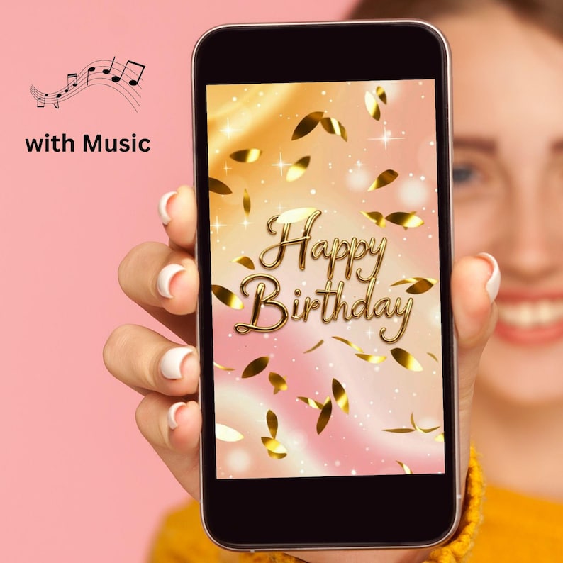 May include: A smartphone displays a birthday greeting with gold text and confetti against a pink and gold background. The words "Happy Birthday" are in a decorative font. The image is held by a person. The words "with Music" and musical notes are in the upper left corner.