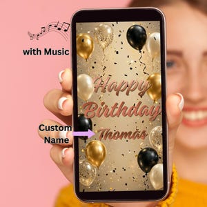 Könnte beinhalten: Ein Smartphone-Bildschirm zeigt einen digitalen Geburtstagsgruß mit schwarzen, goldenen und weißen Luftballons vor einem goldenen Hintergrund. Der Text lautet Happy Birthday und Custom Name mit einem Notensymbol und dem Text with Music.