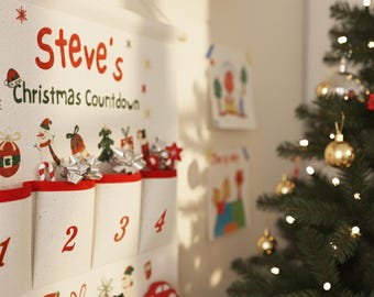Op de afbeelding: Een witte stoffen kerst aftelkalender met rode rand en vakken genummerd 1-4. De kalender is versierd met feestelijke illustraties en de tekst "Steve's Christmas Countdown" in het rood. Een kerstboom met versieringen is op de achtergrond te zien.