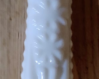 Jarrón vintage de vidrio con leche y tallo único.