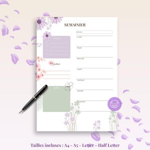 May include: A floral weekly planner with the word "SEMAINIER" at the top. The planner features sections for priorities, notes, and gratitude, with space for each day of the week. A black pen rests on the page, and the design includes purple flowers and petals.