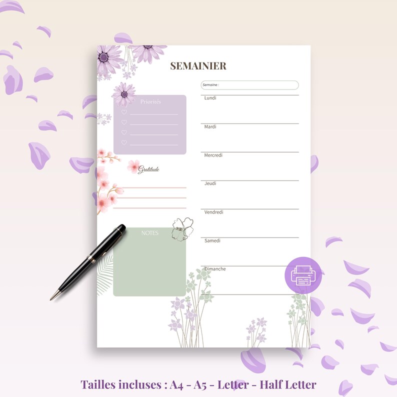 May include: A floral weekly planner with the word "SEMAINIER" at the top. The planner features sections for priorities, notes, and gratitude, with space for each day of the week. A black pen rests on the page, and the design includes purple flowers and petals.