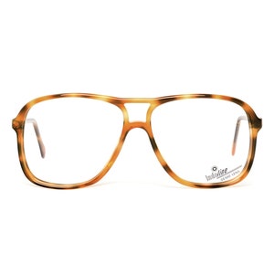 Puede incluir: Gafas de aviador de estilo tortuga con lentes transparentes. El nombre de la marca "Westline" está impreso en la patilla derecha.