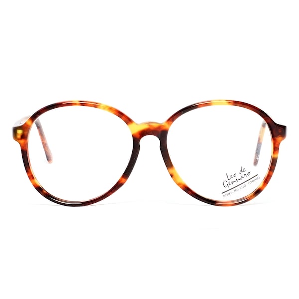 May include: Tortoiseshell round eyeglasses with clear lenses. The brand name "Leo de Gennaro" is printed on the right lens.