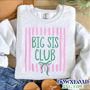 May include: A light gray crewneck sweatshirt featuring a graphic print of vertical pink stripes. Centered on the stripes is the green text "BIG SIS CLUB" in a rounded font, positioned above a small green hand-drawn style bow illustration.