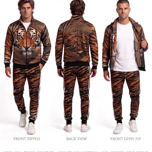 May include: A tracksuit featuring a tiger print pattern, consisting of a zip-up jacket and matching trousers. The jacket displays a large tiger face on the front. The set includes black ribbed cuffs and hem, with white side stripes on the trousers.