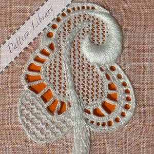 May include: White lace applique with an intricate design, featuring a swirling pattern and orange backing. The applique has a delicate, openwork texture and is set against a peach-colored fabric. The text "Pattern Library" is visible in the upper left corner.