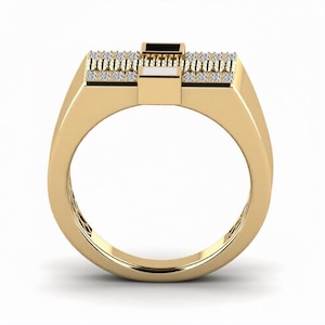 Peut inclure: Une bague dor&eacute;e avec un dessus rectangulaire et un anneau. Le dessus pr&eacute;sente un rectangle noir central, flanqu&eacute; de blanc et de deux rang&eacute;es de petites pierres transparentes. La bague a une finition polie.