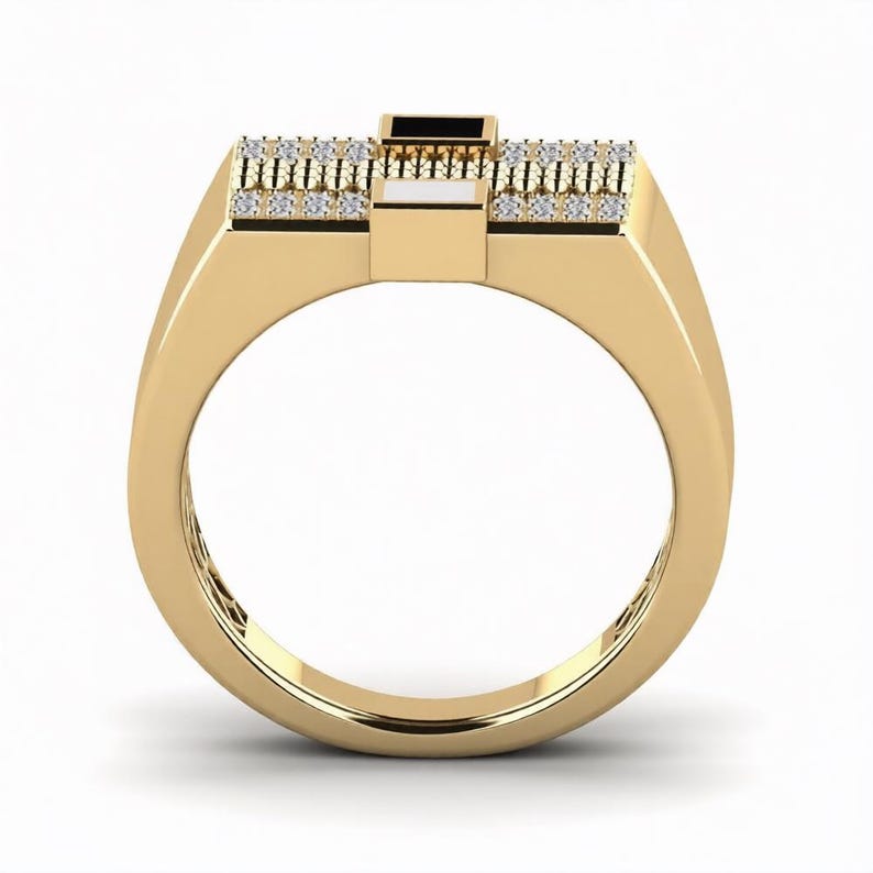 Peut inclure: Une bague dor&eacute;e avec un dessus rectangulaire et un anneau. Le dessus pr&eacute;sente un rectangle noir central, flanqu&eacute; de blanc et de deux rang&eacute;es de petites pierres transparentes. La bague a une finition polie.