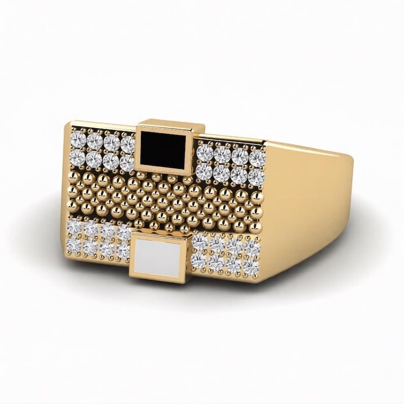 Peut inclure: Une bague dor&eacute;e avec une face rectangulaire. La face pr&eacute;sente un motif de petites sph&egrave;res dor&eacute;es, entrecoup&eacute;es de rang&eacute;es de pierres pr&eacute;cieuses transparentes. Deux petits carr&eacute;s, un noir et un blanc, sont incrust&eacute;s dans la face de la bague.