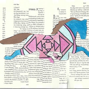 May include: A colourful paper cutout of a horse with a geometric pattern in pink, blue, and brown. The horse is running across a page of text from a book.
