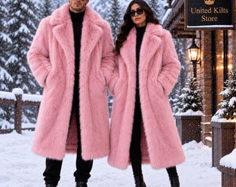 May include: Two long, pink faux fur coats with wide lapels, worn over black turtleneck sweaters and black trousers. Both individuals wear dark sunglasses. A wooden sign with the text United Kilts Store is visible in the snowy outdoor setting.