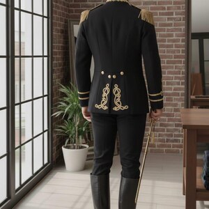 May include: Black military-style jacket with gold trim, epaulets, and decorative embroidery. The jacket is paired with black pants and tall black boots. A gold saber is held at the side. The outfit is formal and elegant.
