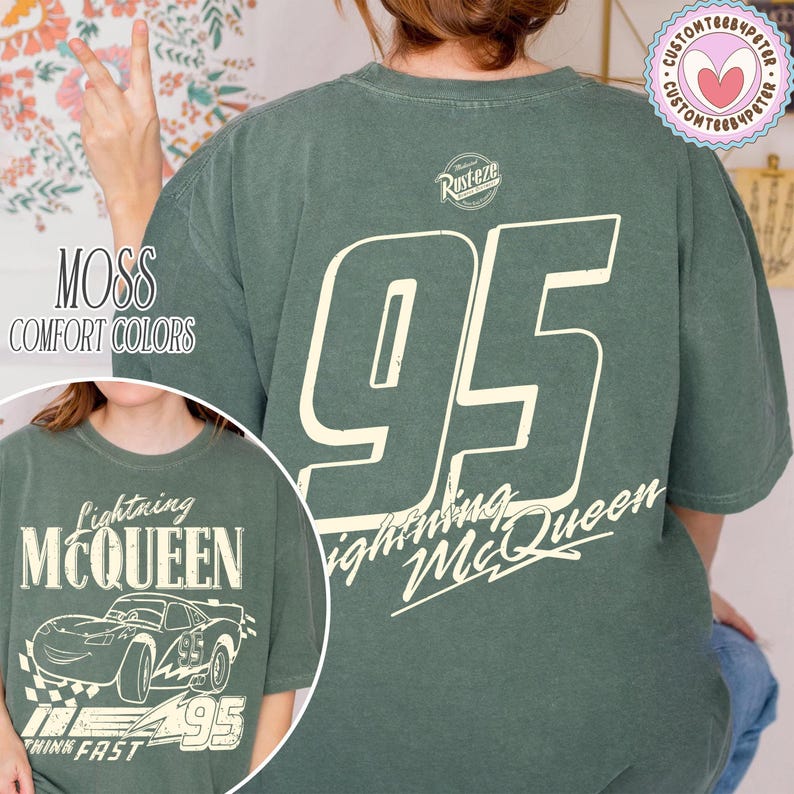 May include: Moss green t-shirt with a large white number 95 on the back and the words "Lightning McQueen" in a stylized font. The front of the shirt features a graphic of Lightning McQueen and the text "Think Fast".