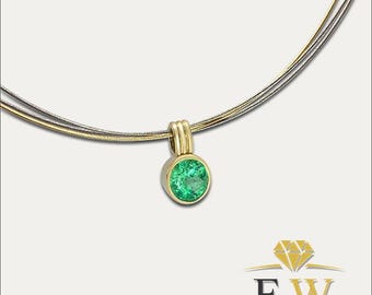 May include: A necklace featuring a round, faceted green gemstone set in a yellow gold bezel pendant. The pendant hangs from a multi-strand chain composed of thin, flexible gold and silver-toned wires. A logo with the letters FW is visible.