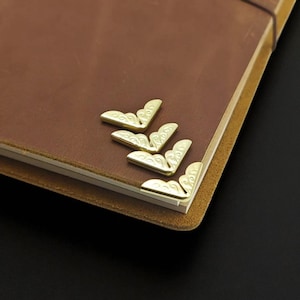 Protectores de bordes para diarios y álbumes de recortes: esquinas metálicas de bronce y banda elástica TN para decorar y proteger cuadernos.