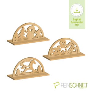 May include: Three wooden Christmas decorations with arched tops and base stands. One features a snowman and trees, another a gingerbread man, and the third a rocking horse and trees. The image includes the text "Digital Download PDF".