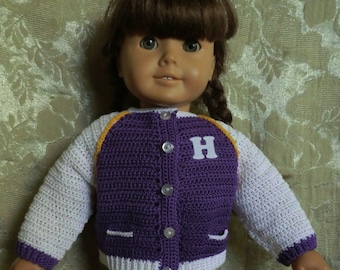 May include: A purple and white crocheted jacket with a yellow trim and a white letter 'H' on the front. The jacket is worn by a doll with brown hair.