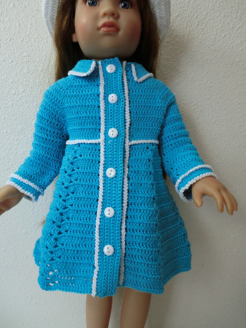 May include: A blue crocheted dress with white trim and buttons. The dress has a fitted bodice and a flared skirt.
