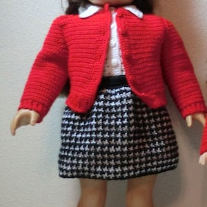 以下が含まれることがあります： 赤い編み物カーディガン、白黒の千鳥格子スカート、赤い編み物帽子、白の編み物靴下と黒い靴を履いた人形です。