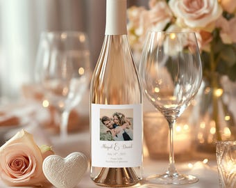 May include: A bottle of rosé wine with a personalised label showing a couple's photo and names. The label reads "Abigail & Daniel, July 18th, 2025, Napa Valley, Northern California." A wine glass and a heart-shaped decoration are nearby.