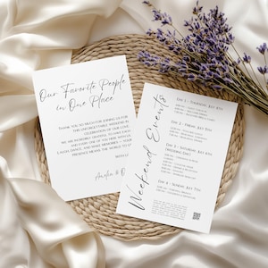 Op de afbeelding: Twee witte kaarten met zwarte tekst, één met de tekst "Onze favoriete mensen op één plek" en de andere met "Weekend Evenementen". De kaarten liggen op een geweven mat met lavendel takjes en een satijnen doek. Het evenementenschema is gedetailleerd.