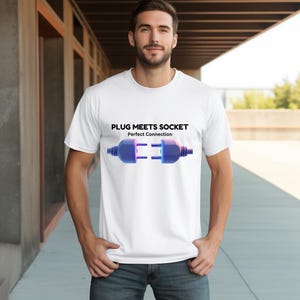 May include: White t-shirt featuring a graphic of a blue plug and socket with the text "PLUG MEETS SOCKET" and "Perfect Connection". The design is centered on the shirt.